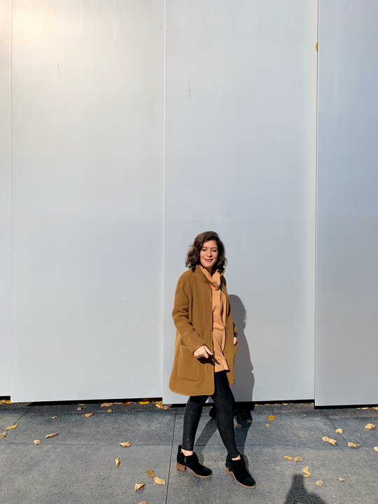 girl in front of wall squinting